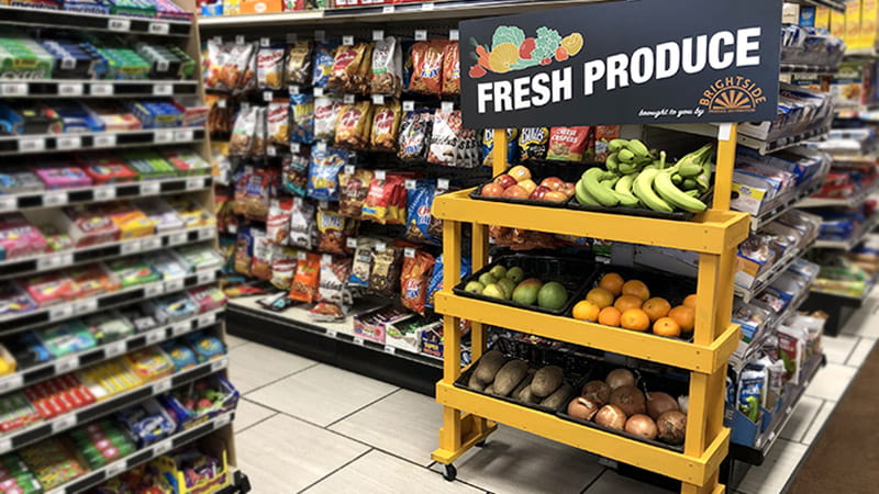 A BrightSide fresh produce stand on a convenience store candy and snack aisle