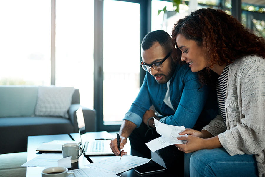 couple sitting in their livingroom looking over paperwork together