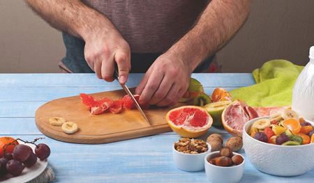 Person cutting fruit on a cutting board