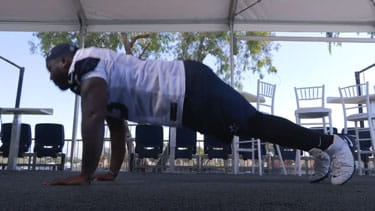 A screenshot of the Dallas Cowboys exercise video showing a player doing a pushup