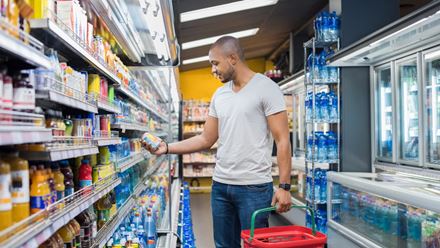 African American man grocery shopping and reading label