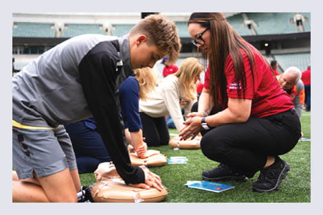 AHA mobile CPR unit training young people in CPR with manikins