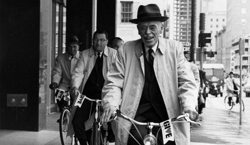 Dr. Paul Dudley White riding a bicycle through downtown