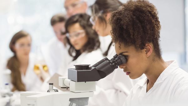 Science student looking through microscope in the lab