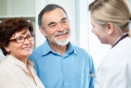 senior couple talking to doctor