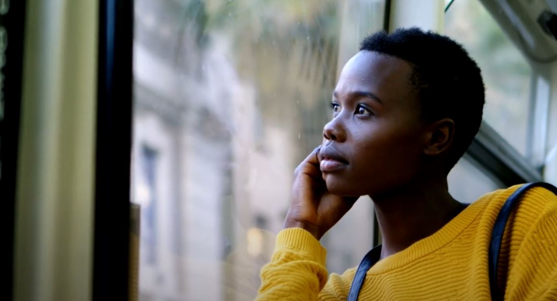 young man looking out the window of a bus