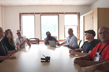 WELD staff gathered around a table for a meeting