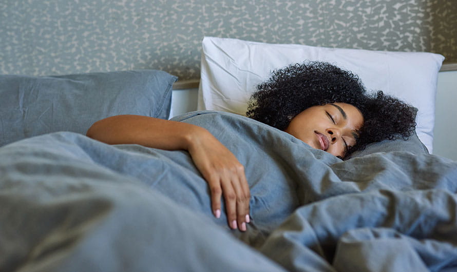 Woman sleeping in her bed at home.